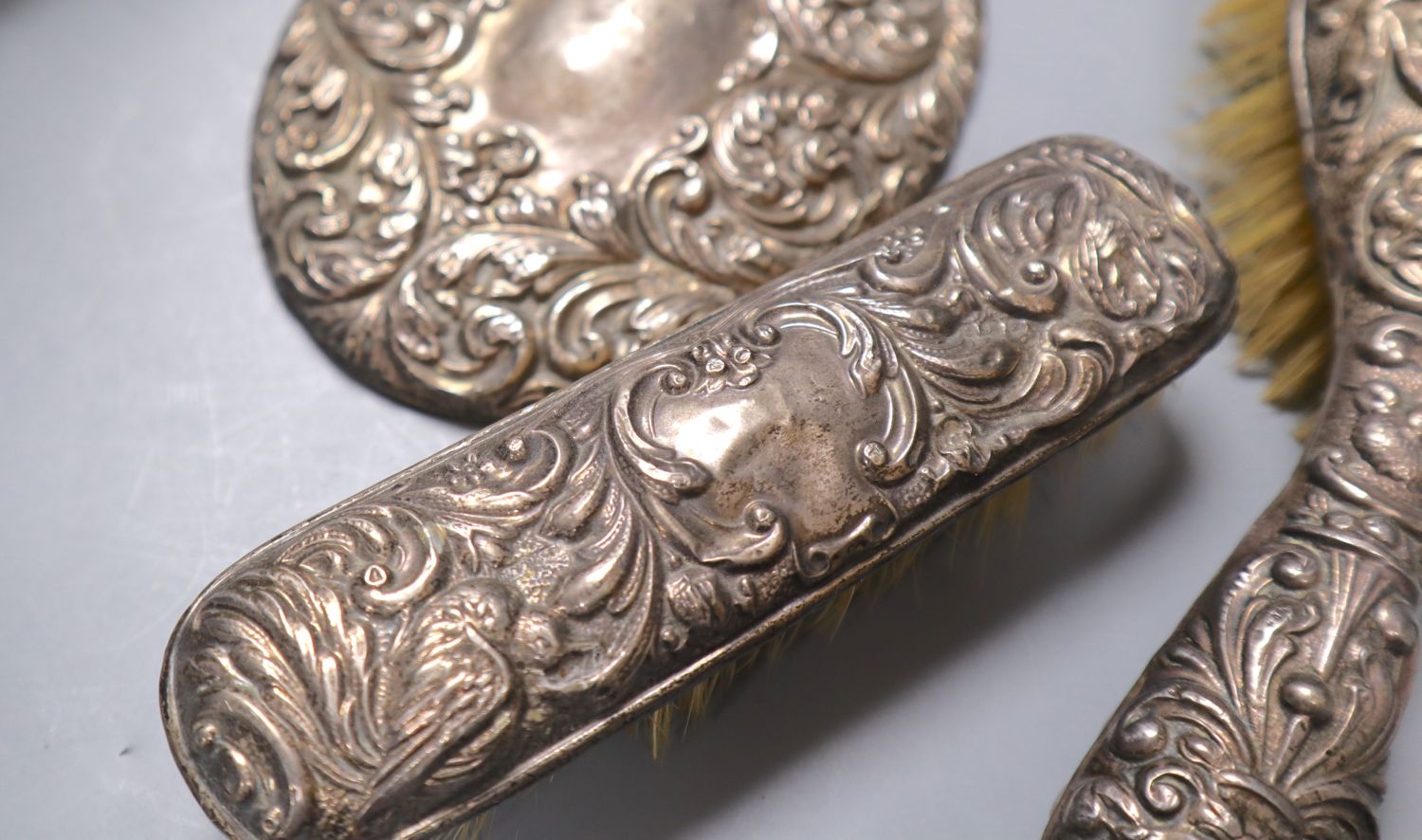 A Victorian cast metal easel mirror and a white metal mounted brush set